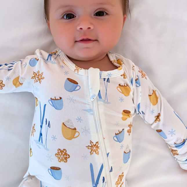 Baby wearing a onesie with coffee-themed design on a neutral background