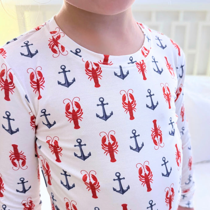 Long-sleeve shirt with red and blue anchor and lobster pattern on a white background