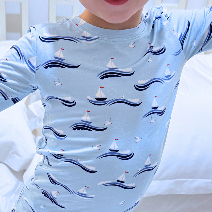 Light blue long-sleeve shirt with sailboat pattern worn by a person.