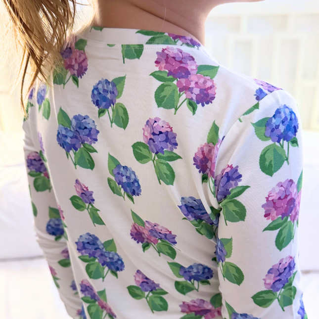 White shirt with purple and blue floral pattern on the back.