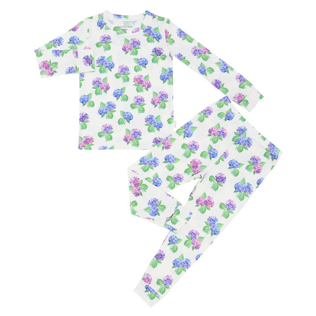 A two-piece pajama set for toddlers with a hydrangea flower pattern in purple, pink, and blue colors on a white background, including a long-sleeve top and matching pants.