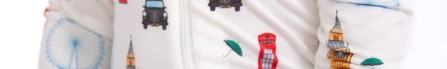 Child wearing a onesie with London-themed pattern on a white background